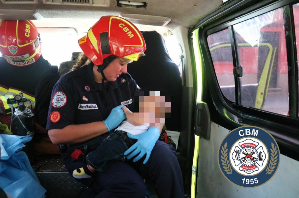 Personal de los Bomberos Municipales alimentan al bebé luego de someterlo a una evaluación médica. (Foto Prensa Libre: CBM)
