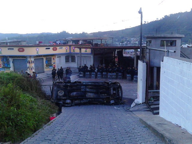 Agentes policiales resguardan un inmueble luego de que una turba linchó al alcalde de Concepción, Sololá. (Foto Prensa Libre: Ángel Julajuj)