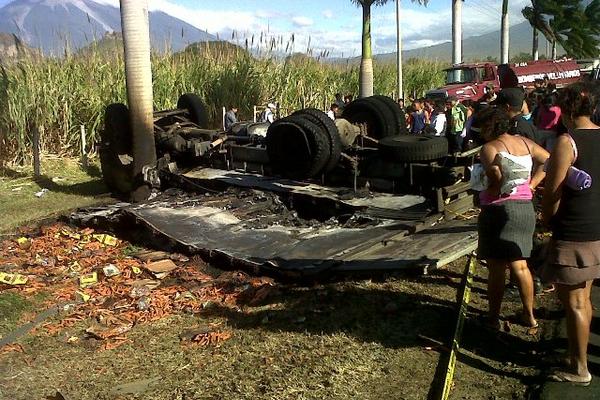 Curiosos observan los restos de un camión repartidor que chocó contra un carro estacionado en la autopista a Palín. (FOTO PRENSA LIBRE: Carlos Paredes)<br _mce_bogus="1"/>