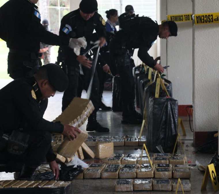 Autoridades antinarcóticas contabilizan la droga decomisada. (Foto Prensa Libre: PNC).