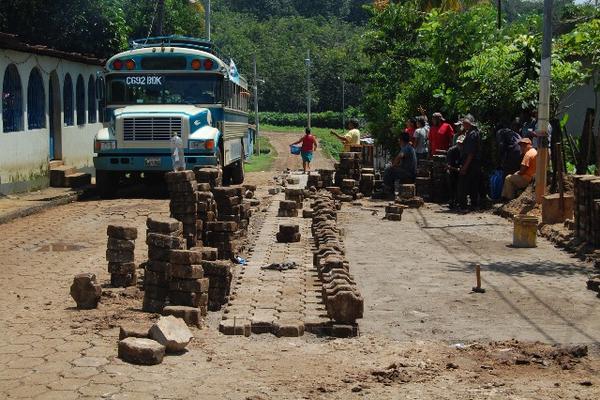 Vecinos trabajan  en la reparación de un tramo al que la comuna no le da mantenimiento. (Foto Prensa Libre: Alexánder Coyoy)