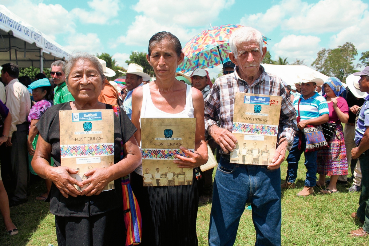 Tres de los beneficiados con escrituras de terrenos en Petén. (Foto Prensa Libre: Rigoberto Escobar)