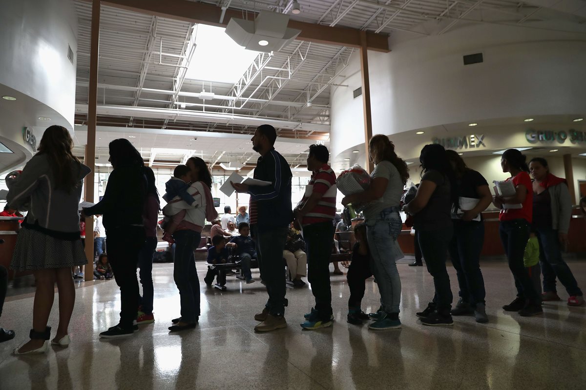 Familias de inmigrantes esperan a ser registrados en oficinas de inmigración de Macallen, Texas. (Foto Prensa Libre: AFP).