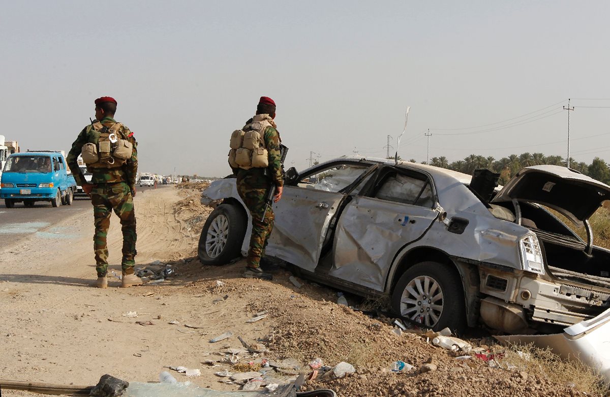 Soldados iraquíes inspeccionan el carrobomba utilizado por los yihadistas en el atentado. (Foto Prensa Libre: AFP).