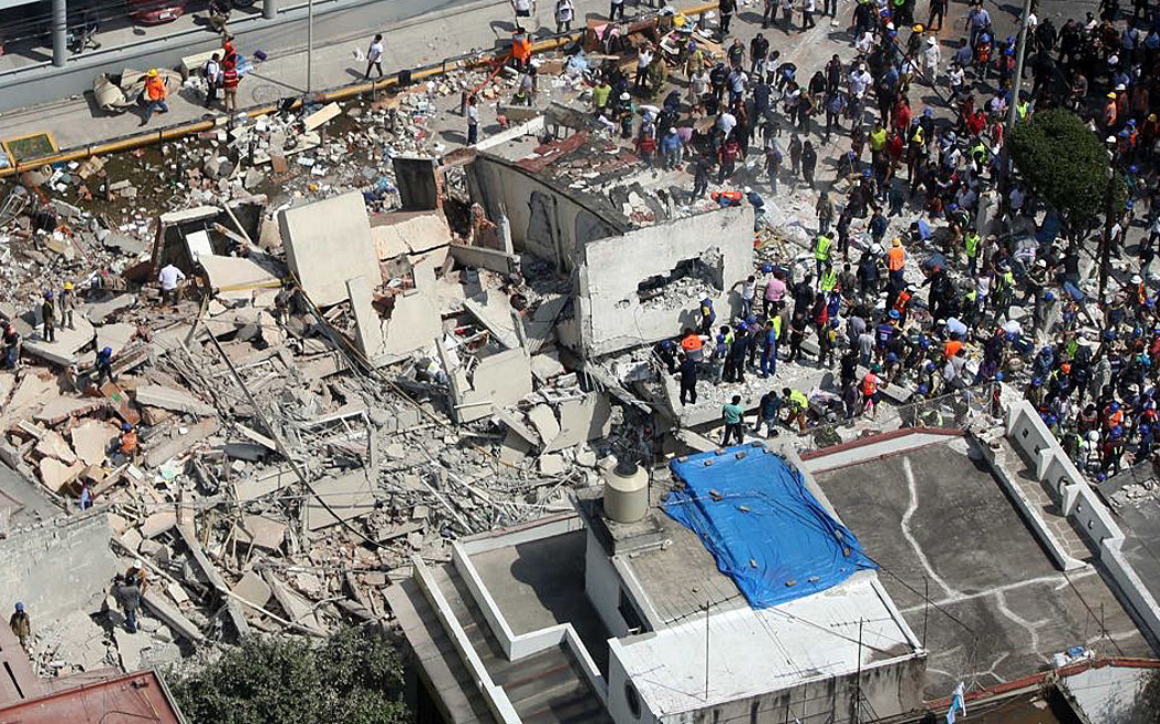 Decenas de personas buscan a sobrevivientes entre escombros de un inmueble derrumbado. (Foto Prensa Libre: EFE)