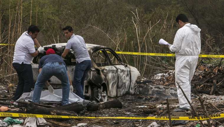 Forenses recaban evidencias en el vehículo que fue hallado en el lugar. (Foto Prensa Libre: EFE).