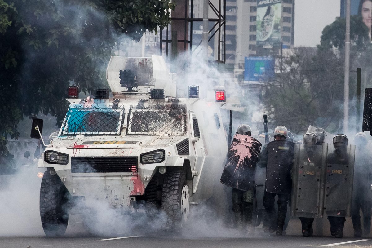 Una de las últimas modalidades de manifestantes es lanzar pintura a las fuerzas de seguridad en Venezuela. (Foto Prensa Libre: EFE)