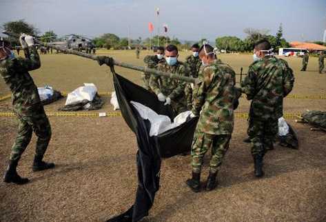 Soldados colombianos trasladan cuerpos de guerrilleros de las Farc en el aeropuerto militar de Tame. (Foto Prensa Libre: AFP).