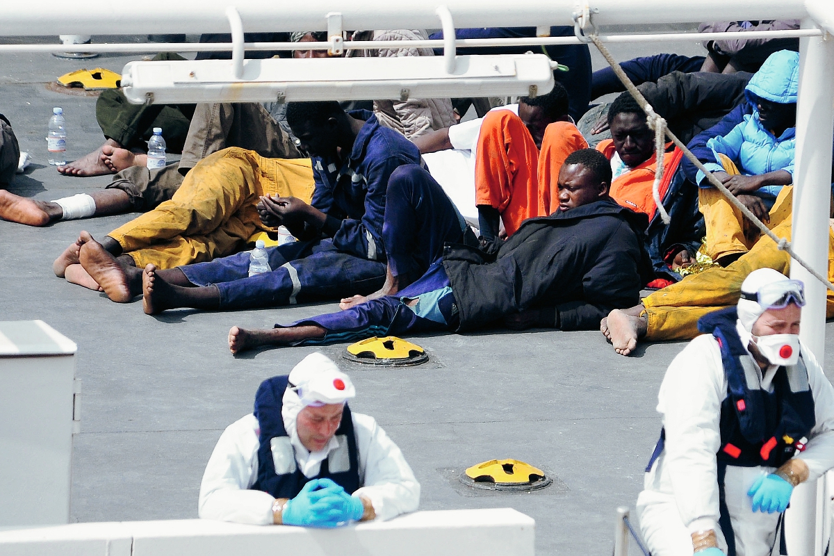 Migrantes esperan a ser atendidos luego de ser rescatados en las aguas del Mediterráneo. (Foto Prensa Libre: AP).