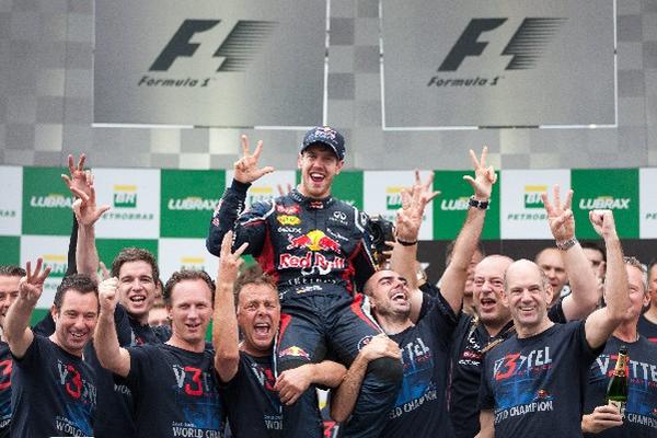 El piloto alemán Sebastián Vettel, de Red Bull, celebró con su equipo la obtención del tricampeonato en la Fórmula 1. (Foto Prensa Libre: EFE)