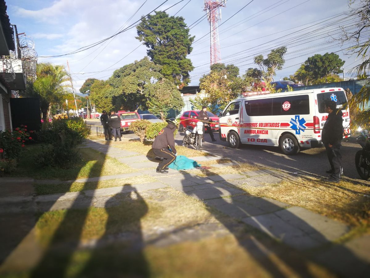 Socorristas observan el cuerpo de la mujer ultimada por un sicario. (Foto Prensa Libre: Estuardo Paredes)