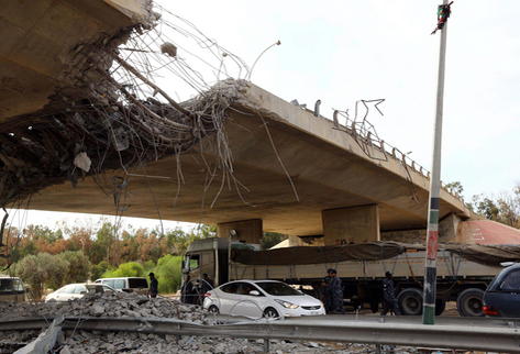 Policías custodian un puesto de control bajo cerca del lugar donde se enfrentan milicias rivales, en Trípoli, Libia. (Foto Prensa Libre/EFE)
