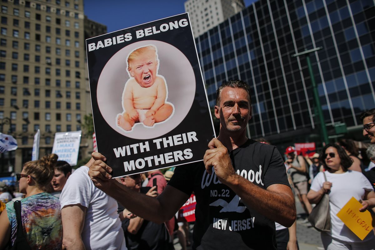 Miles de personas manifiestan contra las políticas de separación de familias migrantes en Estados Unidos. Con este cartel que dice: "Los bebés pertenecen a sus madres", un hombre se suma a la protesta. (Foto Prensa Libre: AFP)