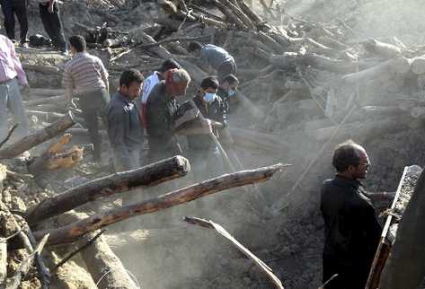 Varios residentes de la localidad de Varzaqan buscan entre los escombros en la localidad de Varzaqan, tras dos fuertes terremotos. (Foto Prensa Libre: EFE)