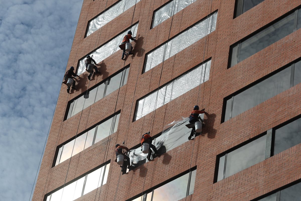 Empleados limpian vidrios en un edificio de la zona 10. (Foto Prensa Libre: Érick Ávila)