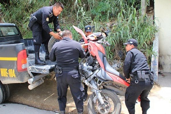 Agentes policiales suben en un autopatrulla una de las motocicletas decomisadas en Huehuetenango. (Foto Prensa Libre: Mike Castillo)