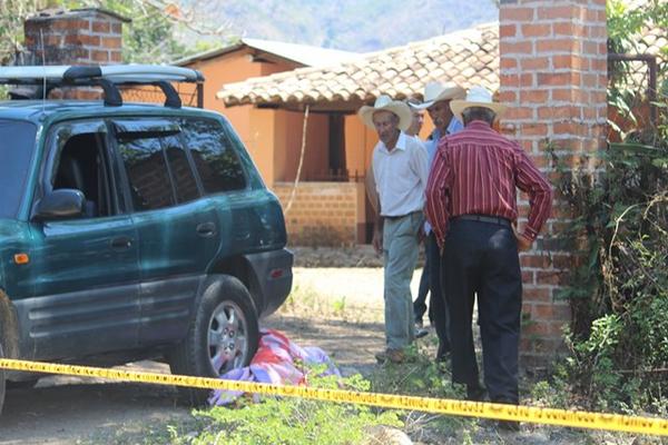 Parientes observan la escenta del crimen contra el subinspector de la PNC Daniel Armando Cámbara Oliveros, en una aldea de Jutiapa. (Foto Prensa Libre: Óscar González)