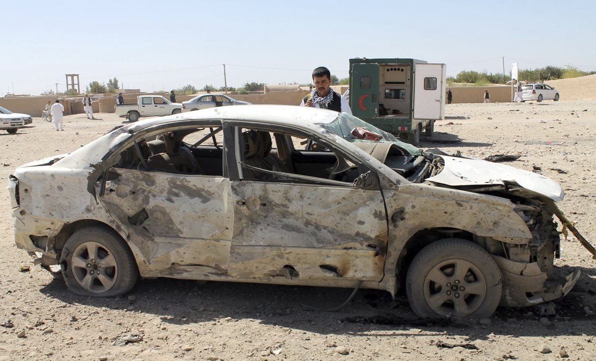 Investigadores inspeccionan el lugar donde ocurrió el atentado con un carro bomba. (Foto Prensa Libre: EFE).