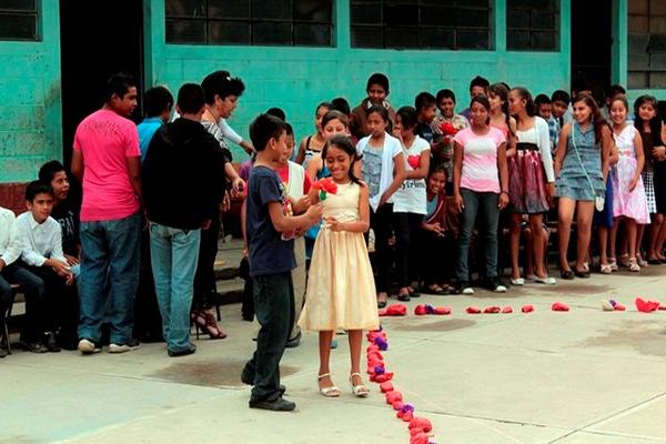 Un estudiante regala una rosa a una de sus compañeras en la escuela Las Piedrecitas, en Salamá. (Foto Prensa Libre: Carlos Grave)