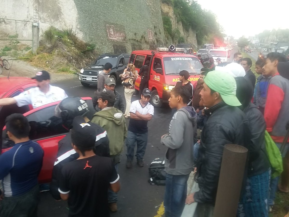 Curiosos observan el trabajo de los bomberos que asistieron a uno de los automovilistas. (Foto Prensa Libre: Bomberos Voluntarios)