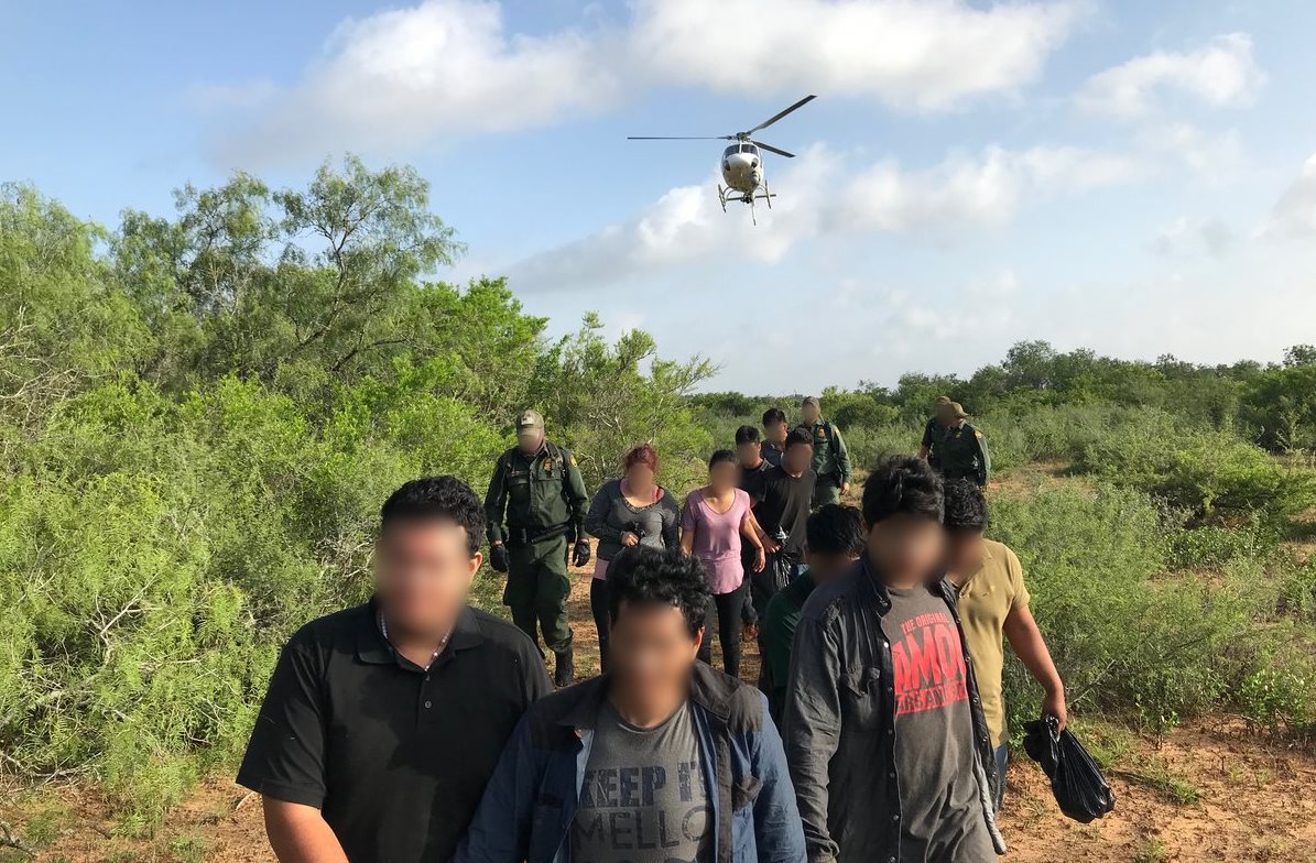 Migrantes aprehendidos en la frontera sur de EE. UU. son custodiados por guardias de la Patrulla Fronteriza. (Foto: CBP)