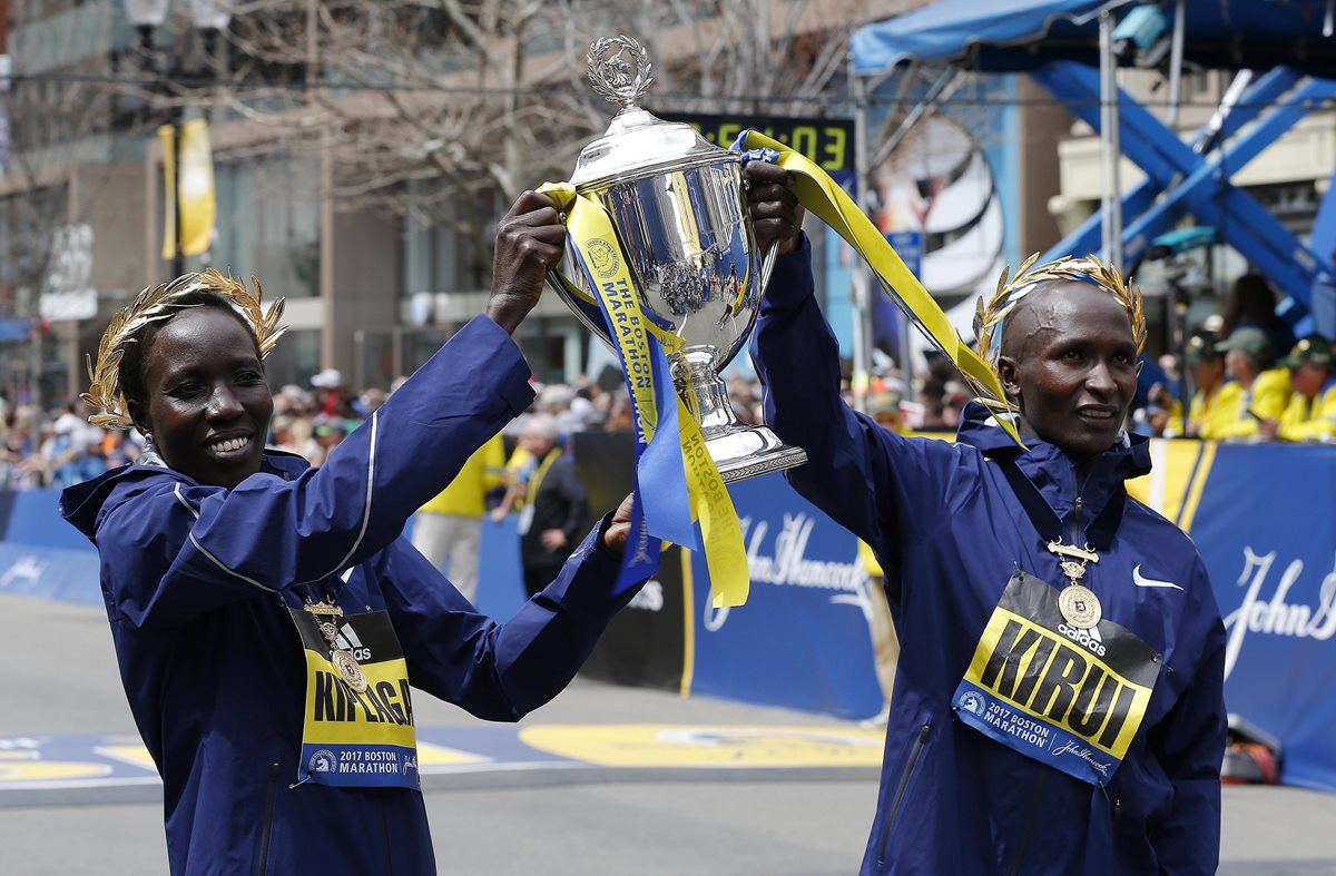 Los kenianos Geoffrey Kirui (derecha) y Edna Kiplagat (izquierda) celebran al final de El Maratón de Boston. (Foto Prensa Libre: EFE)