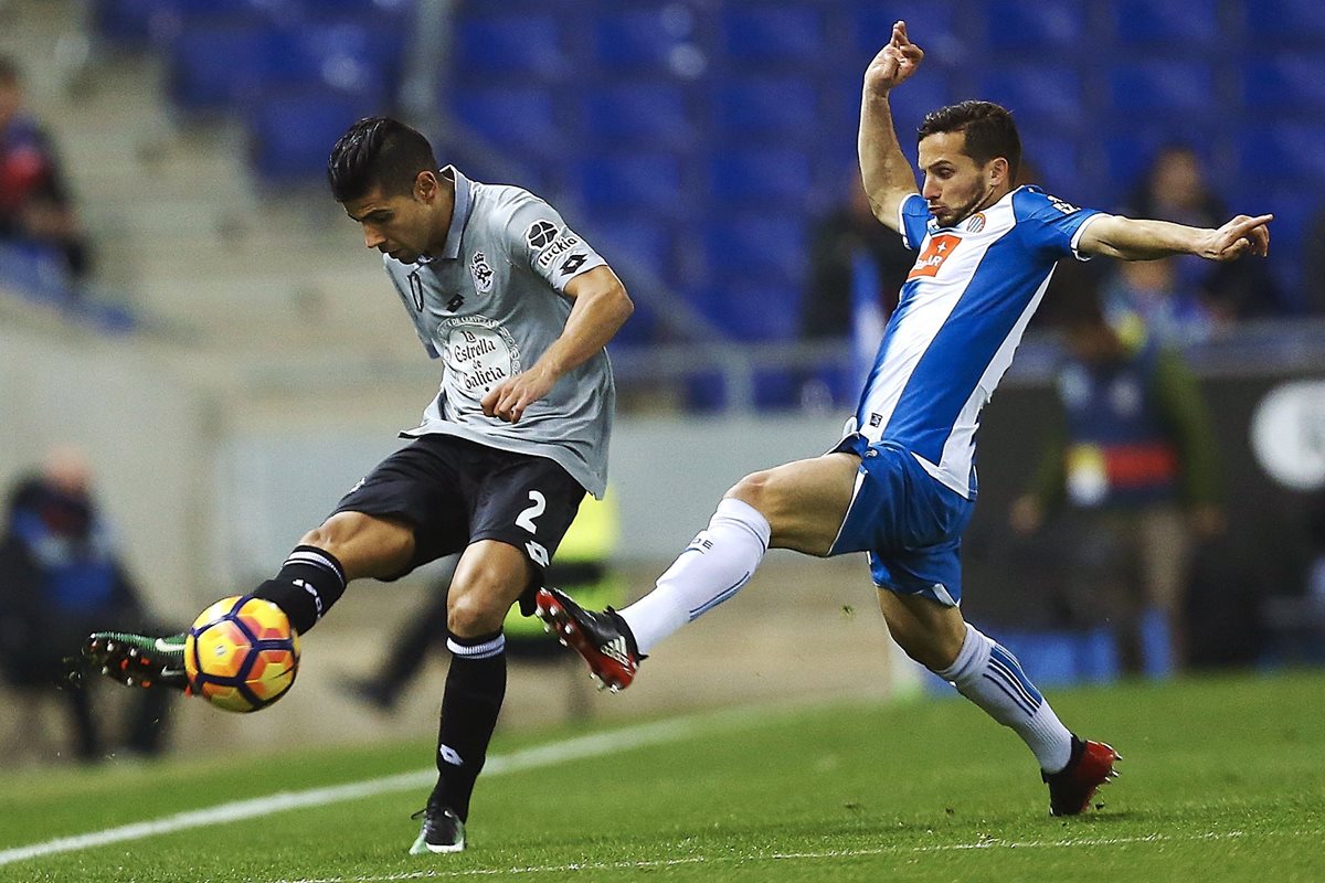 El defensa del Deportivo de la Coruña, Juan Francisco Moreno "Juanfran" (i), despeja el balón ante el delantero argentino del Espanyol, Pablo Piatti (Foto Prensa Libre: EFE)