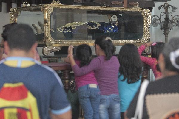Curiosos observan  la imagen del Cristo Yacente de El Calvario, después de restaurado. (Foto Prensa Libre: Álvaro Interiano)