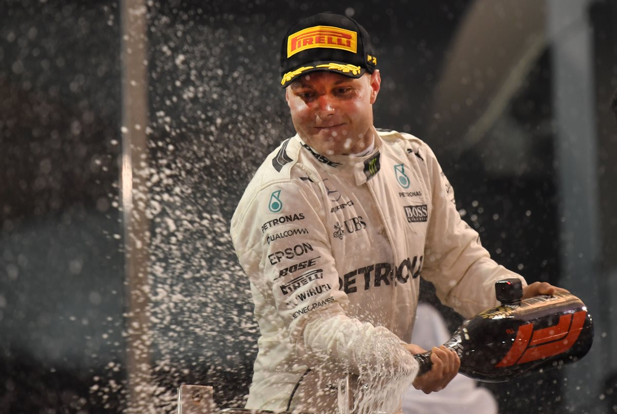 Valtteri Bottas celebra en el podio con el tradicional baño de champán. (Foto Prensa Libre: AFP)