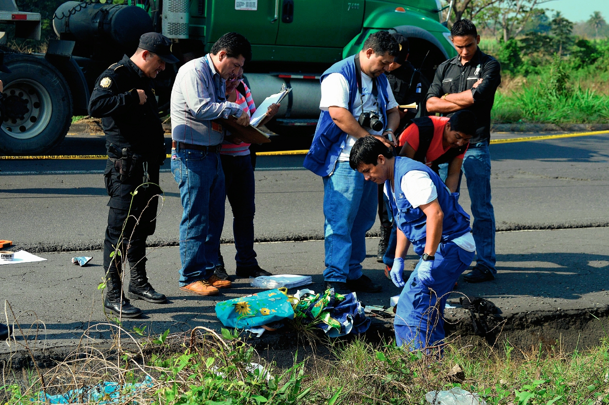 Fiscales del  Ministerio Público examinan el  lugar en  donde fue hallado el cadáver de una mujer, en Siquinalá, Escuintla. (Foto Prensa Libre: Carlos Paredes)