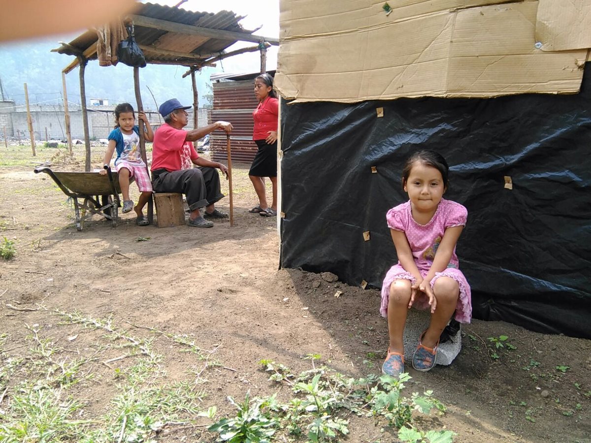 Una niña aguarda la decisión de sus padres para abandonar su humilde vivienda, en Amatitlán. (Foto Prensa Libre: Estuardo Paredes)