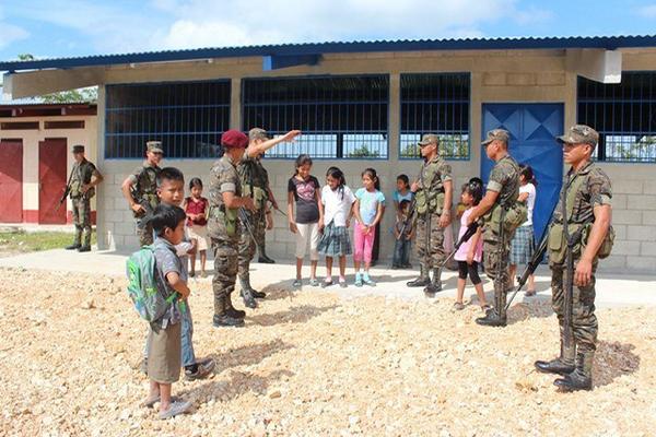 Soldados conversan con estudiantes de la escuela del barrio El Arroyo, en San Benito. (Foto Prensa Libre: Rigoberto Escobar)