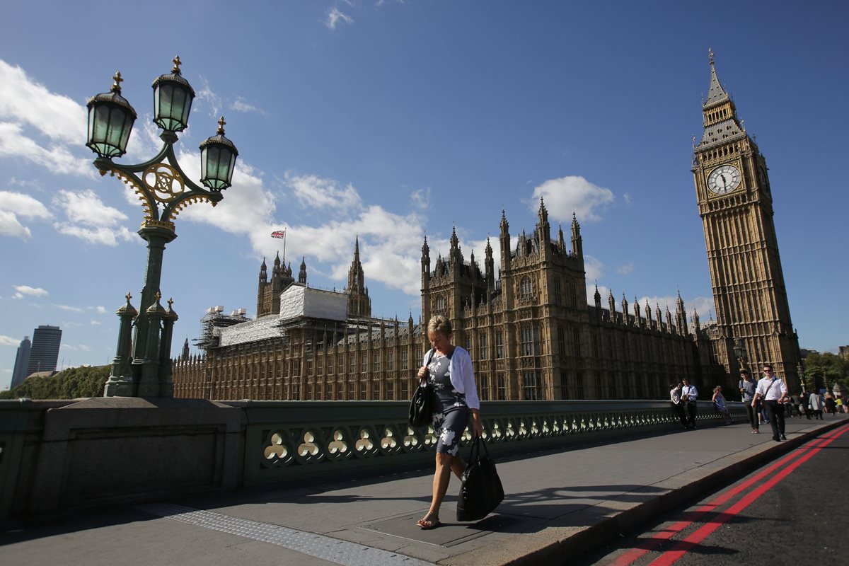 Una mujer camina frente al Palacio de Westminster, sede del Parlamento británico. (Foto Prensa Libre: AFP).