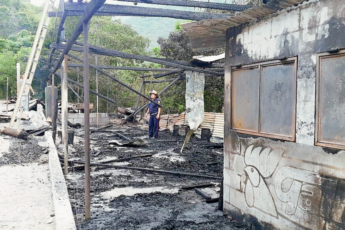 Socorrista observa los daños que causó un incendió en un negocio, en Río Hondo, Zacapa. (Foto Prensa Libre: Víctor Gómez)