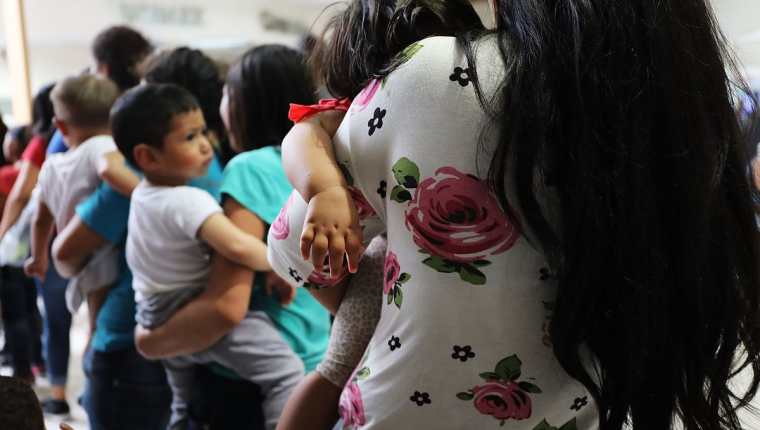 Madres con sus hijos abordan un bus luego de ser liberados de un centro de detención en McAllen. (Foto Prensa Libre: AFP)