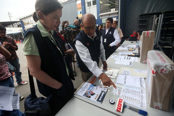  Un funcionario conversa con una observadora durante el traslado de material electoral.(EFE).