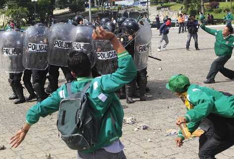 Supuestos estudiantes de la Escuela Normal para Varones arremeten contra un  contingente de policías  antidisturbios, en  el Parque de la Industria, a quienes lanzan piedras y palos.