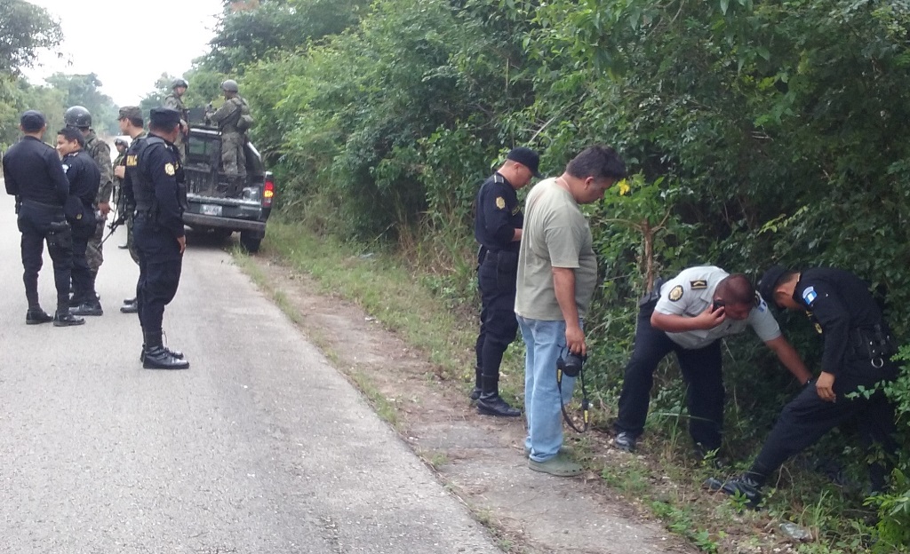 Agentes de la PNC observan el cadáver que fue hallado en San Miguel, Flores, Petén. (Foto Prensa Libre: Rigoberto Escobar)