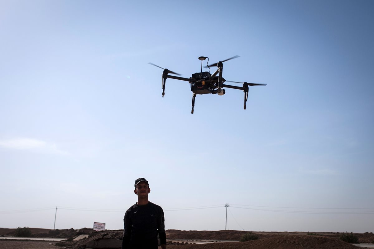 Un policía iraquí observa el vuelo de un dron cerca de Arbid, en el frente sur de Mosul. (Foto Prensa Libre: AFP).