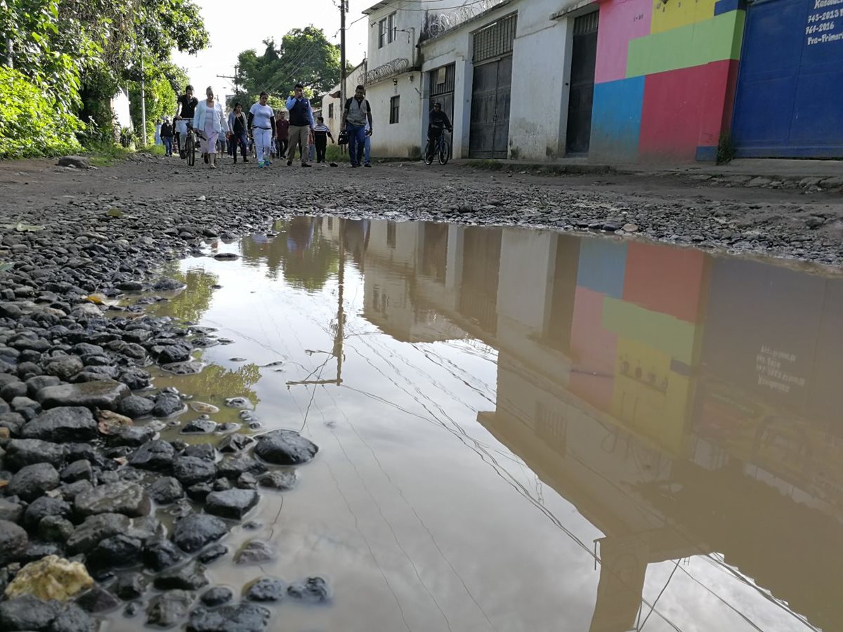 Los vecinos de la colonia Los Álamos, zona 6 de San Miguel Petapa, exigen la reparación de las calles. (Foto Prensa Libre: Esbin García)