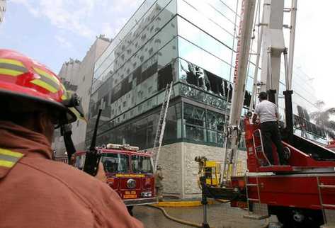 Bomberos rompen vidrios para sofocar las llamas. (Foto Prensa Libre: Alvaro Interiano)
