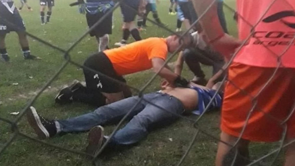 El árbitro Darío Cid aplica los primeros auxilios al entrenador. (Foto Prensa Libre: Tomado de redes sociales)