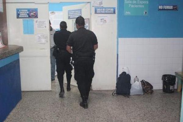 Dos agentes de la PNC brindad seguridad a la sala donde son atendidos los heridos. (Foto Prensa Libre: Edwin Paxtor).<br _mce_bogus="1"/>