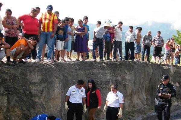 Curiosos observan el cadáver de Bryan Alexander Barcárcel, quien murió atropellado en San Cristóbal Acasaguastlán. (Foto Prensa Libre: Héctor Contreras)