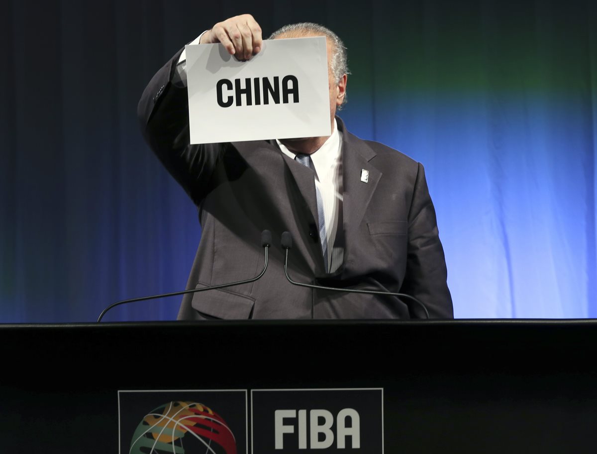 Horacio Muratore, presidente de FIBA sostiene el cartel con el nombre de la sede del mundial de 2019. (Foto Prensa Libre: AP)