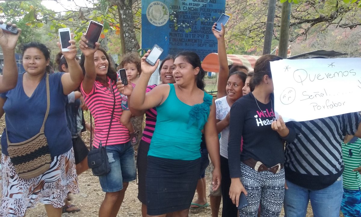 Un grupo de mujeres, con celulares en mano, protesta en tres colonias de Santa Elena por la falta de señal de telefonía. (Foto Prensa Libre: Rigoberto Escobar)