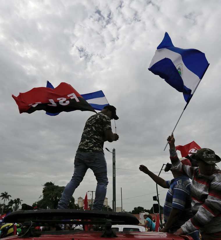 Manifestantes ondean banderas en la marcha a favor de Daniel Ortega.  (AFP)