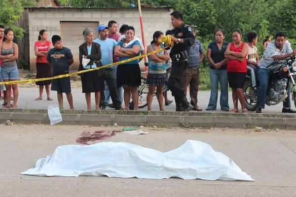 Curiosos observan el cadáver de Dionisio Amador, de 76 años, quien murió lapidado frente a una iglesia evangélica de San Benito, Petén. (Foto Prensa Libre, Rigoberto Escobar)<br _mce_bogus="1"/>