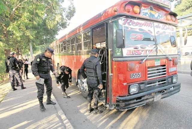Agentes de la PNC revisan un autobús atacado en la zona 6. (Foto Prensa Libre: Hemeroteca PL)