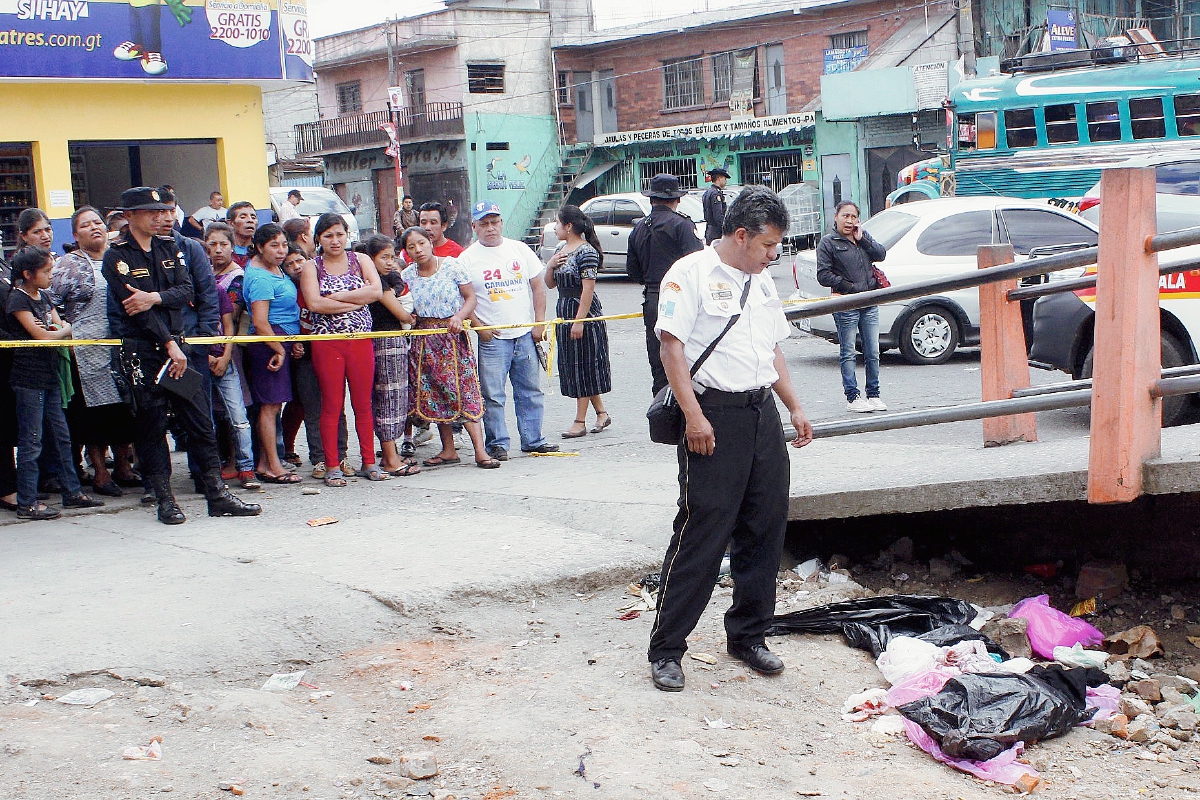 Vecinos de la cabecera de Chimaltenango observan la bolsa plástica donde desconocidos introdujeron el cadáver de un bebé. (Foto Prensa Libre: Víctor Chamalé)